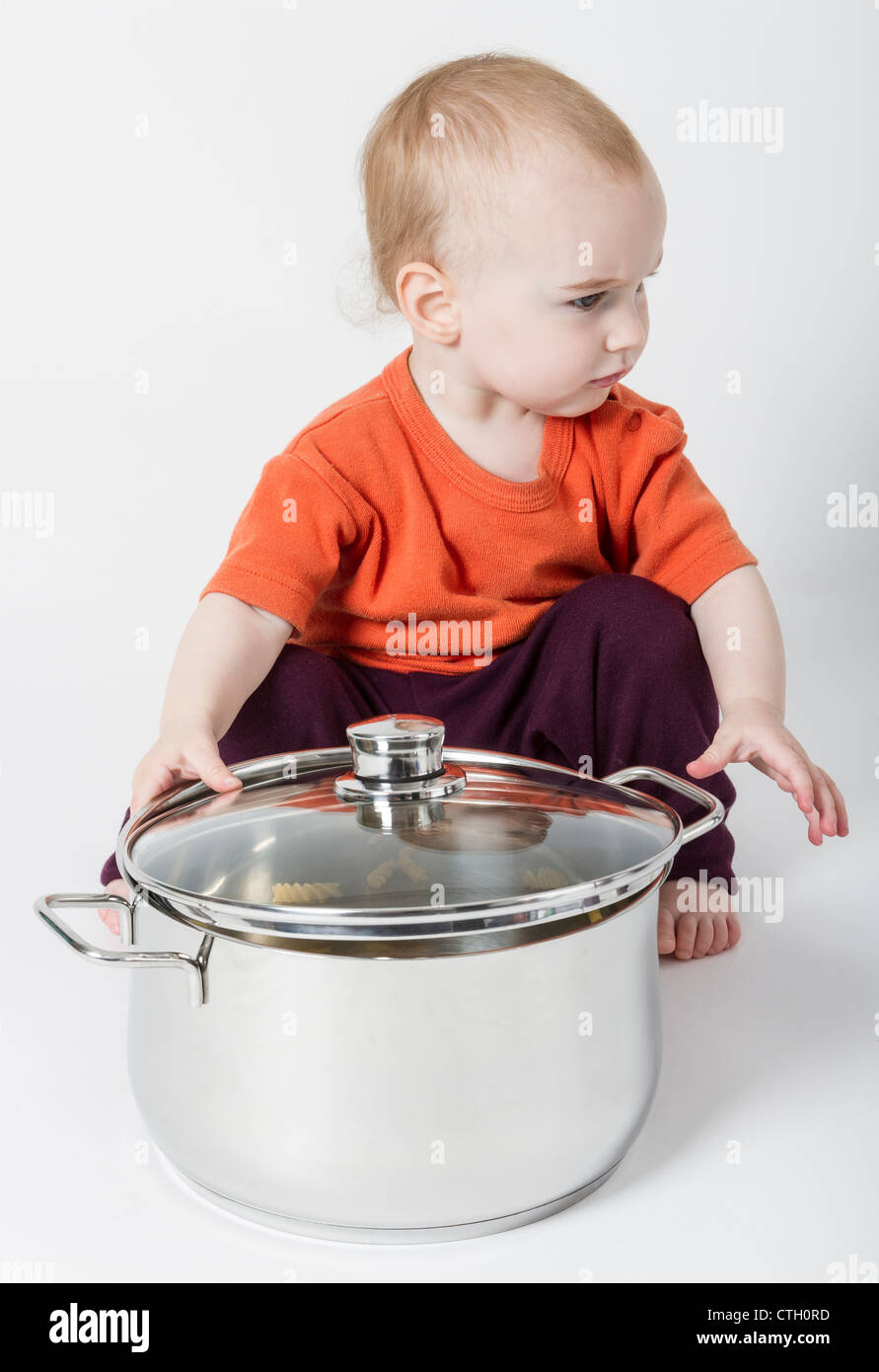 baby with big cooking pot isolated on grey background Stock Photo