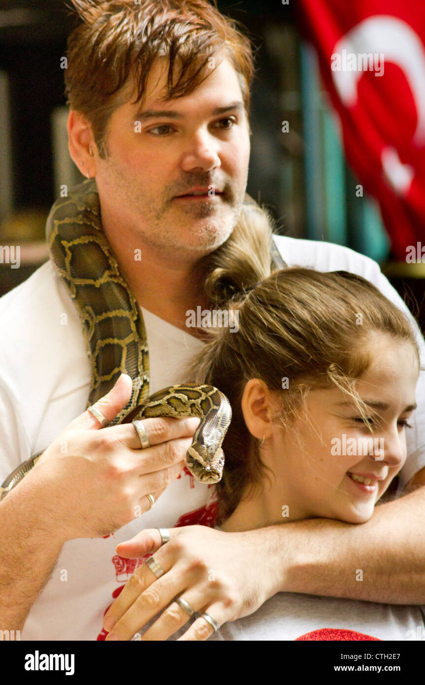 caucasian tourists posed with pythons snake in batu cave, kuala lumpur, malaysia. Stock Photo