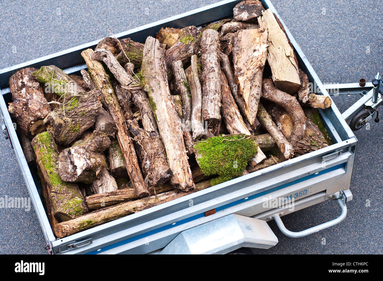 Small trailer loaded with rough logs for fire-wood - sud-Touraine, France. Stock Photo