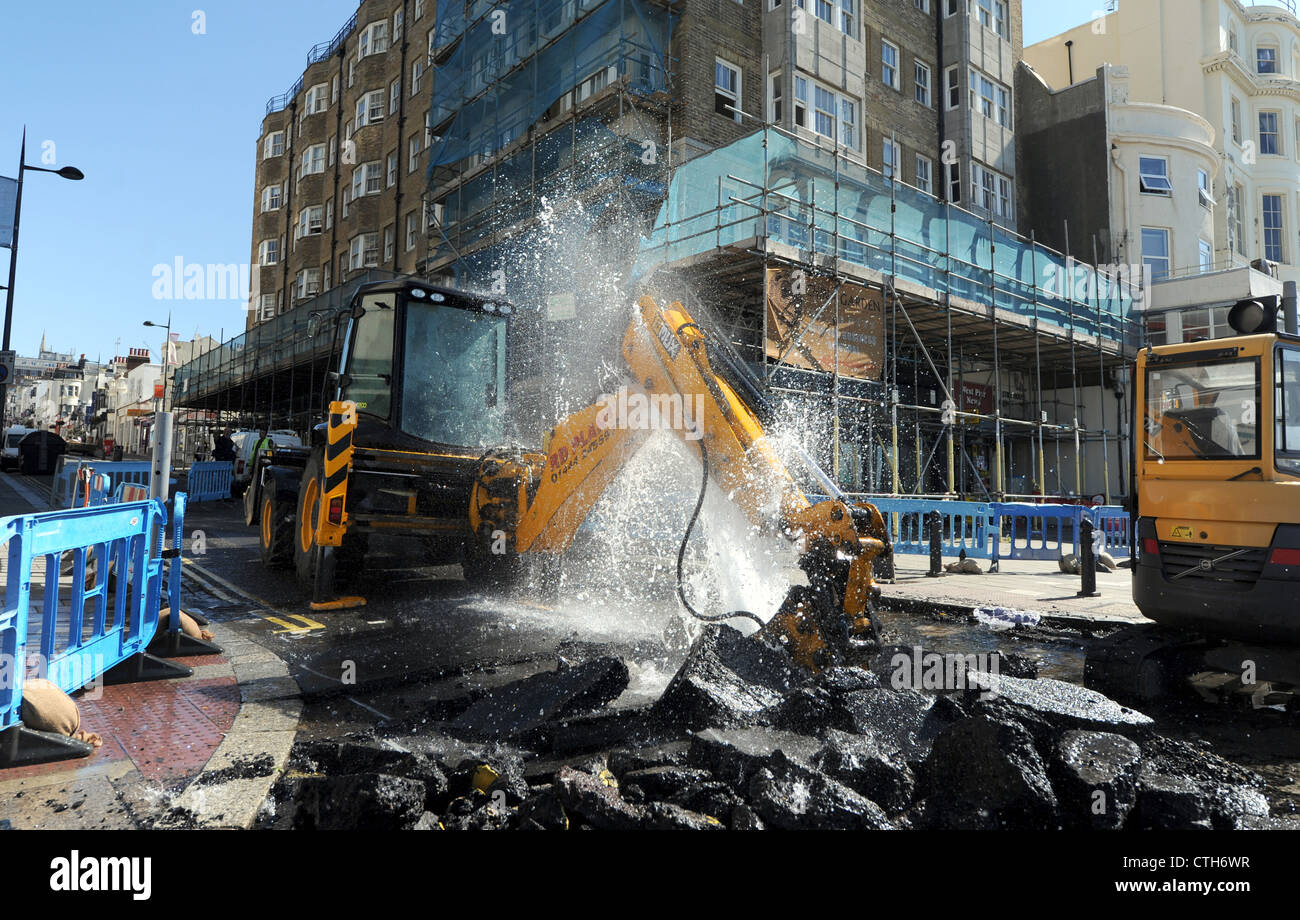 Water spouts out of the road at the bottom of Preston Street in Brighton after a JCB digger went through a mains pipe Stock Photo