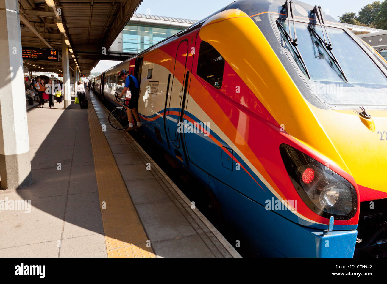 Passenger getting off an East Midlands Trains HST train with a bicycle, Sheffield Station, England, UK Stock Photo