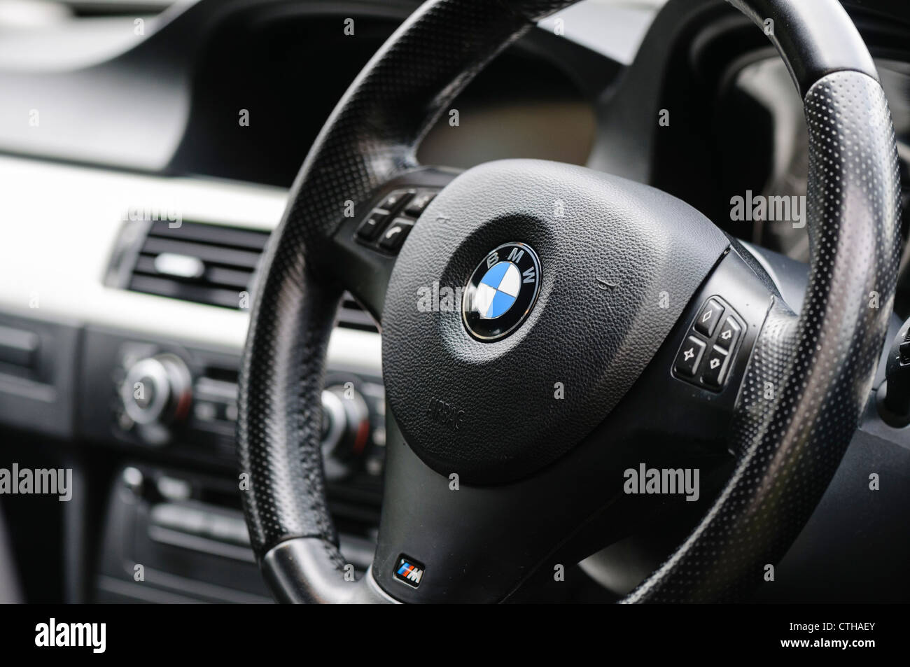 Steering wheel on a 2008 BMW 318i with remote control buttons for radio