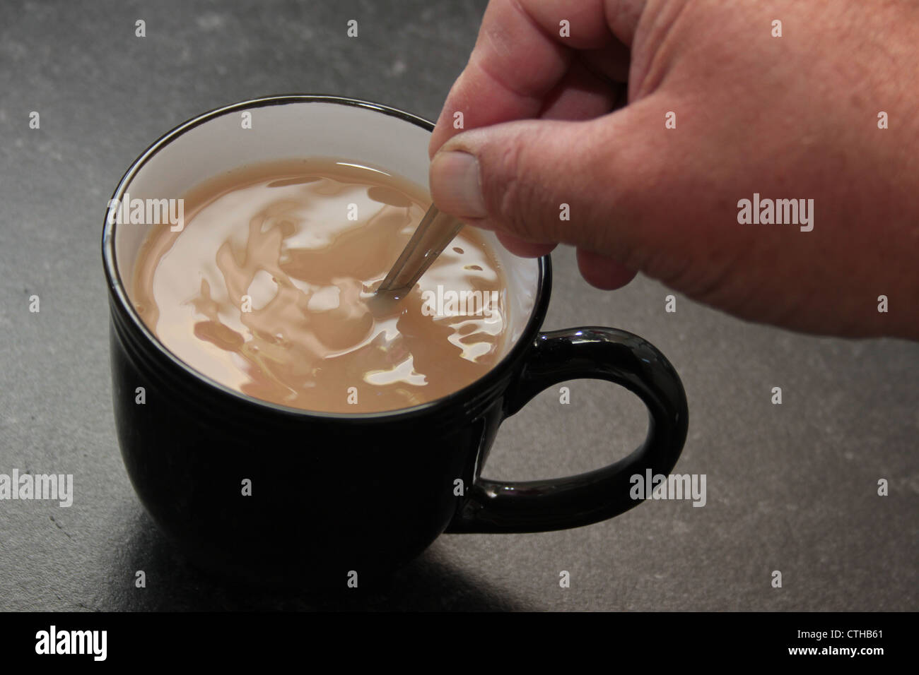 close up of hand stirring a cup of tea or coffee Stock Photo Alamy