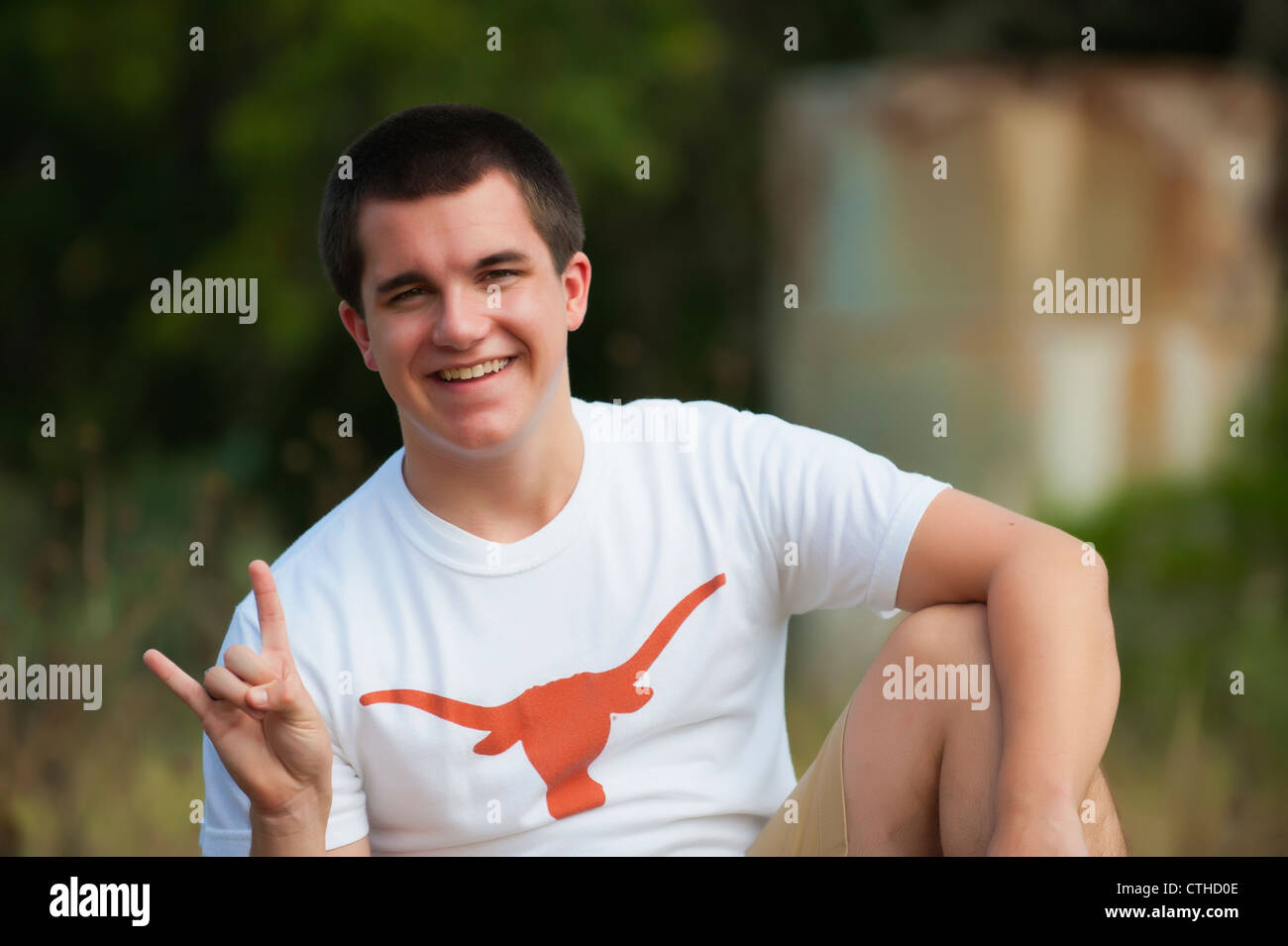 Male highschool senior, 17 years old, in Texas Longhorns t-shirt, Concan, Texas, USA, showing hand symbol for success Stock Photo