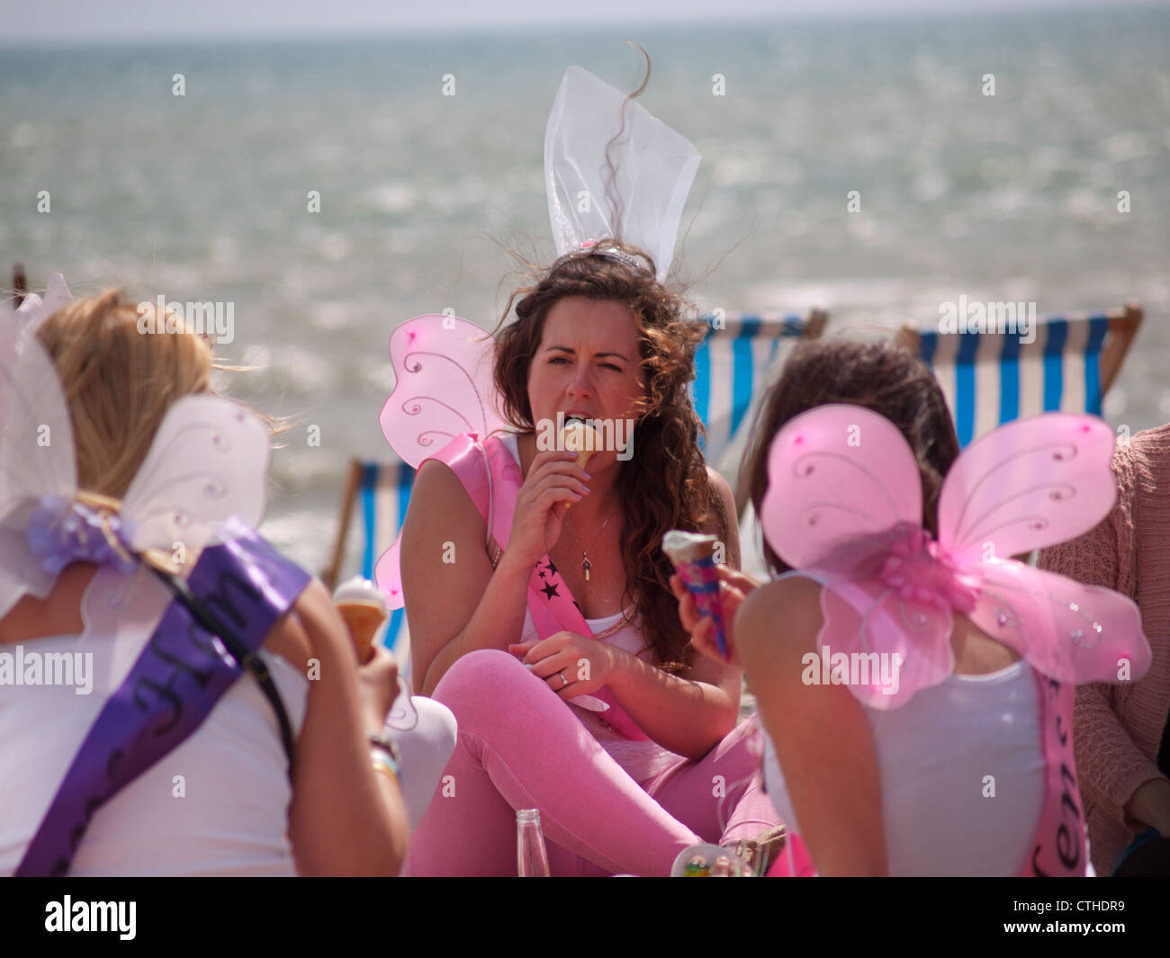 At a hen party on the beach at Brighton girls wear fairy wings and eat
