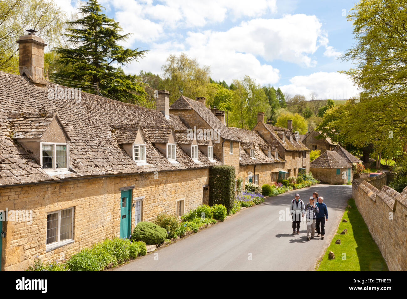 Hikers enjoying the stone cottages beside the lane in the Cotswold village of Snowshill, Gloucestershire UK Stock Photo