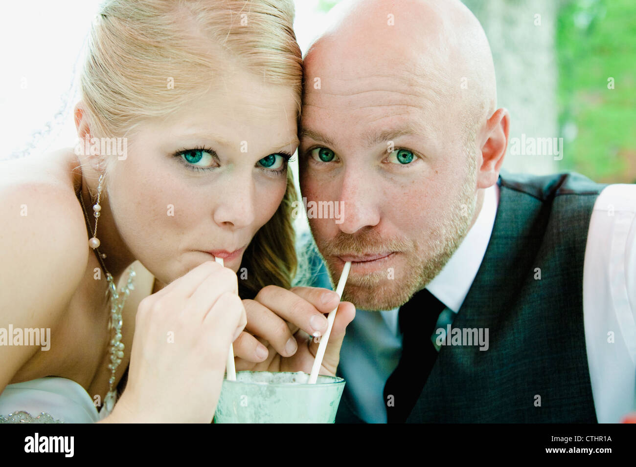 Bride And Groom Sipping Through Straws From The Same Glass; Grand