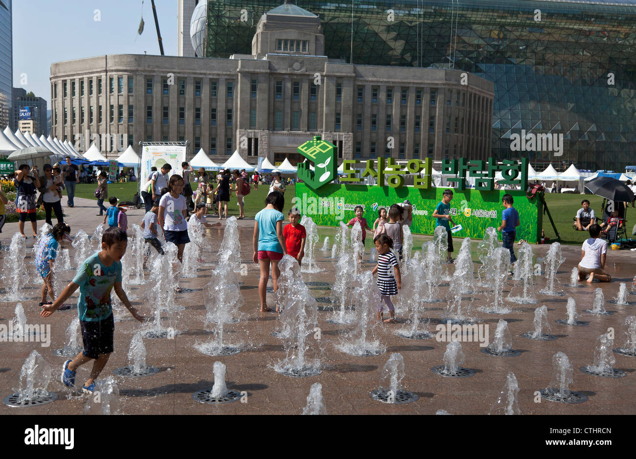 Children play in the water at Seoul Plaza's floor water fountain Stock ...