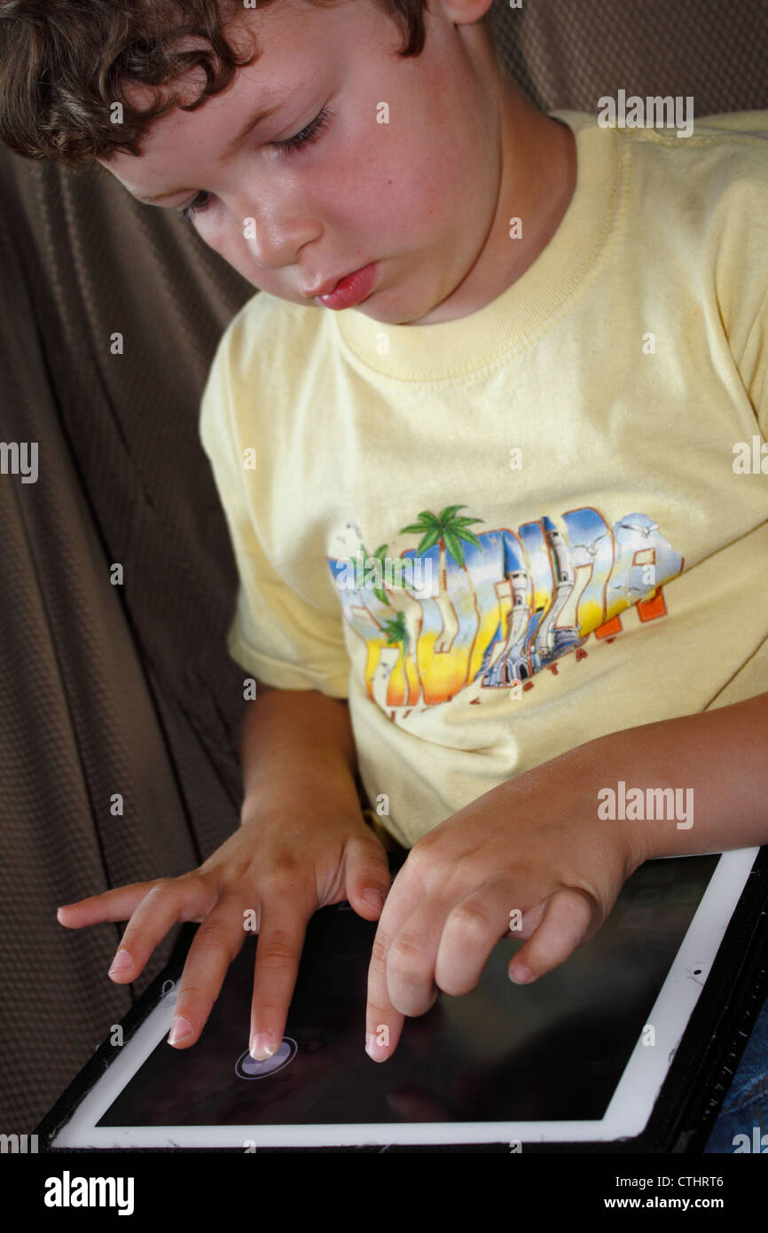 A 5 or 6 year old Caucasian boy using an iPad tablet computer wireless