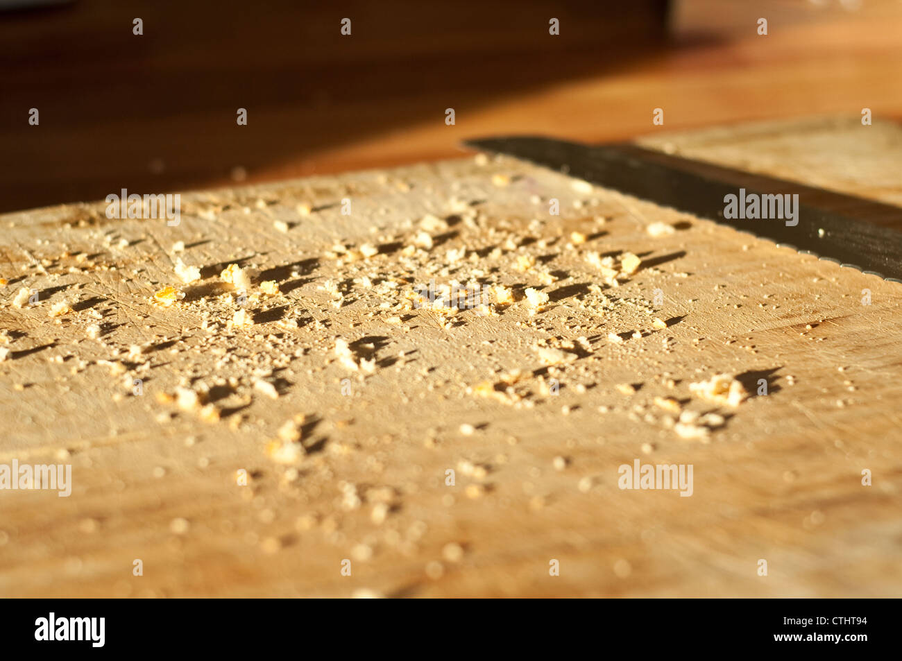 Bread crumbs and knife on a wooden chopping board Stock Photo