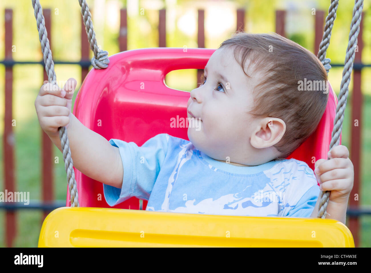 9-month old baby boy in a swing outdoors Stock Photo