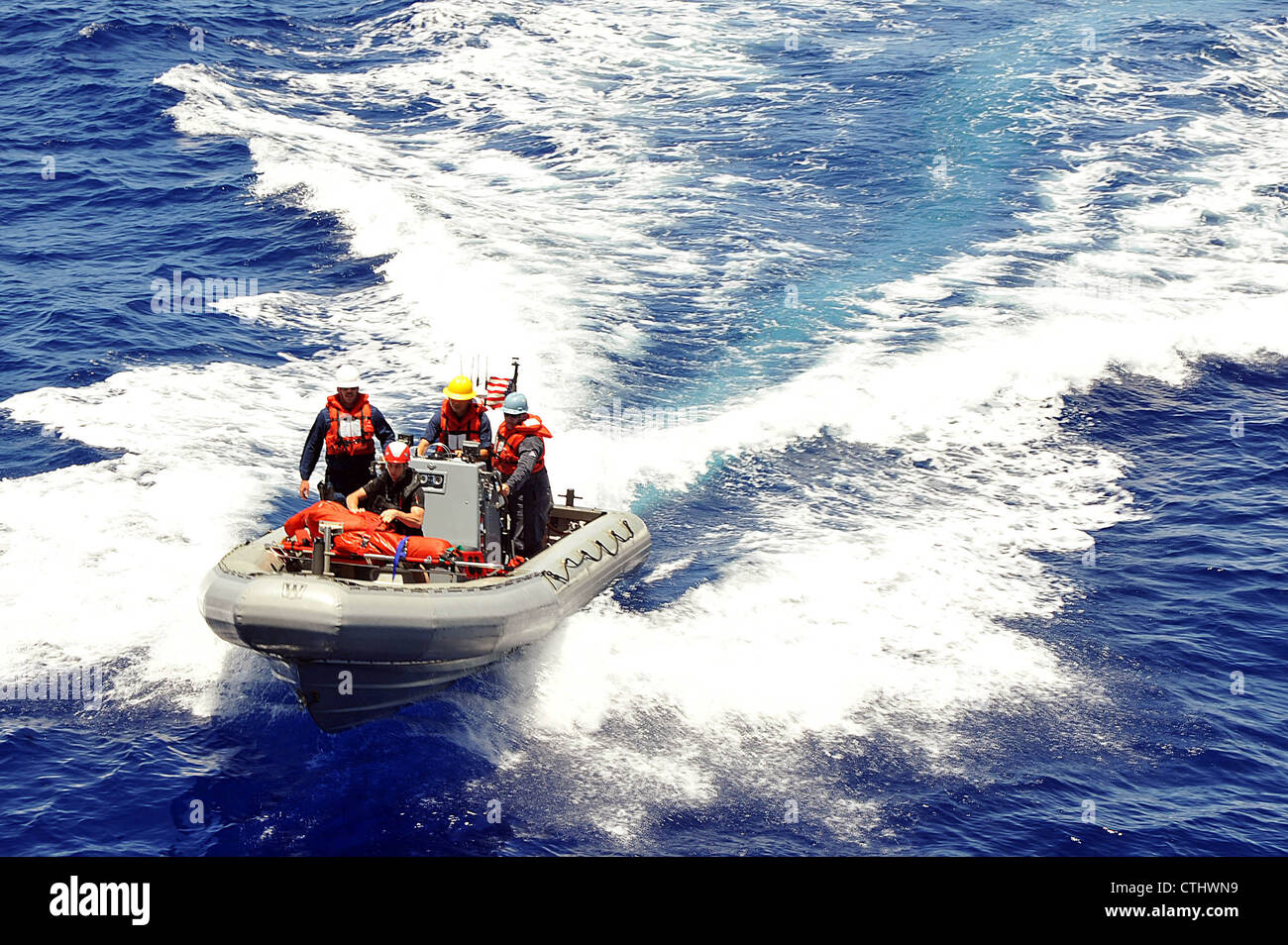 Sailors assigned to the Arleigh Burke-class guided-missile destroyer USS McCampbell (DDG 85) return to the ship after rescuing a simulated casualty in the water during a man overboard drill at sea. McCampbell is forward deployed to Yokosuka, Japan, and is underway in the U.S. 7th Fleet area of responsibility. Stock Photo