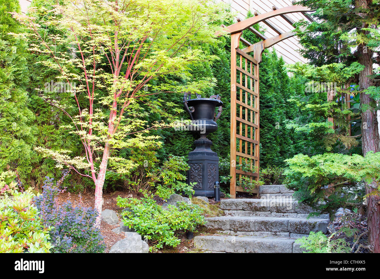 Garden Entrance with Arbor Stone Steps Urn Pot and Trees Stock Photo