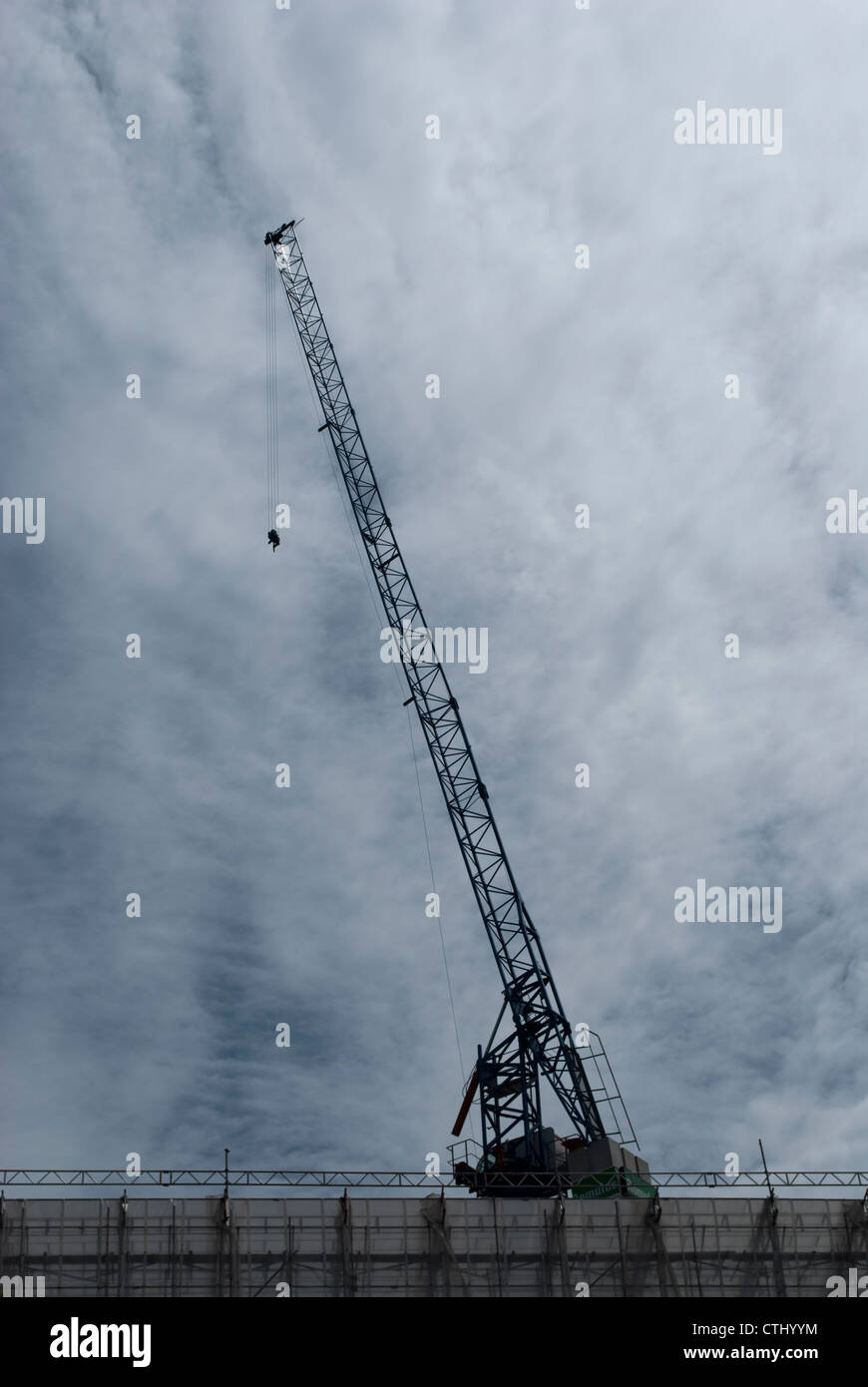 Jib of tower / construction crane silhouetted against a cloudy sky ...