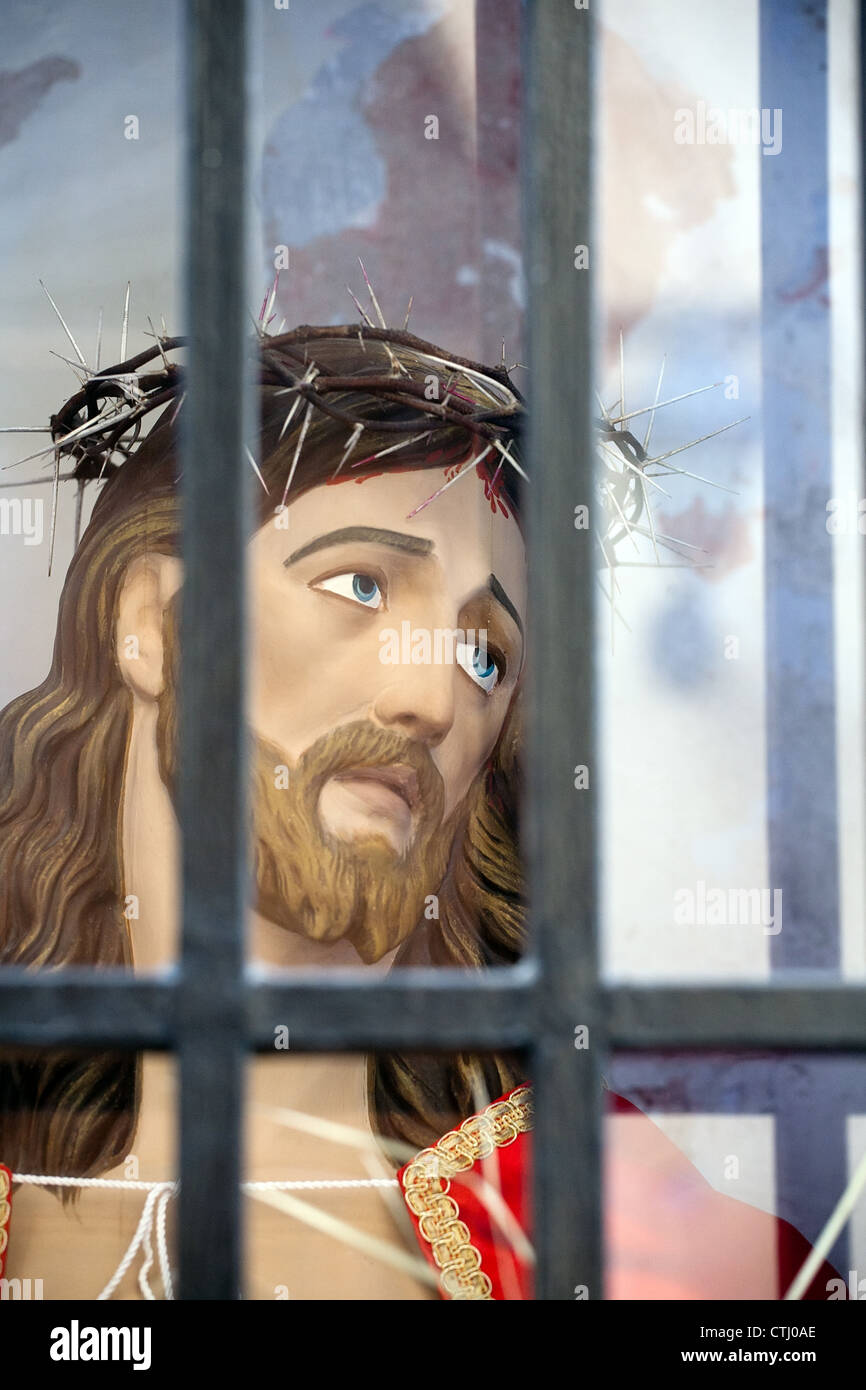 closeup of Jesus Christ head statue behind bars Stock Photo