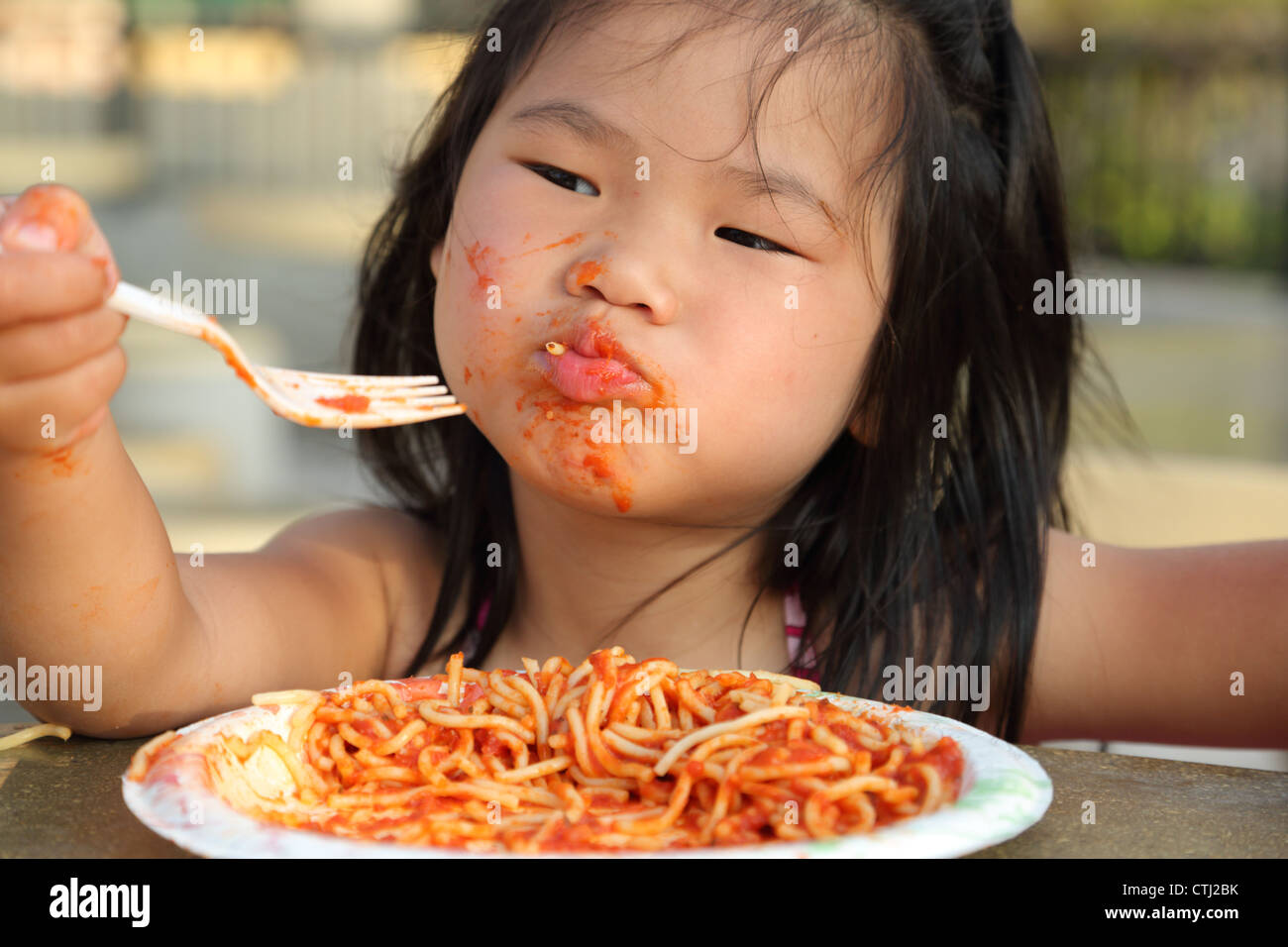 Young girl eating spaghetti and making mess Stock Photo