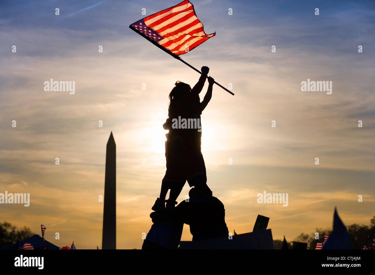 Two immigrants on top of human pyramid waving a U.S. flag in Iwo Jima fashion at march of illegal immigrants in Washington DC. Stock Photo