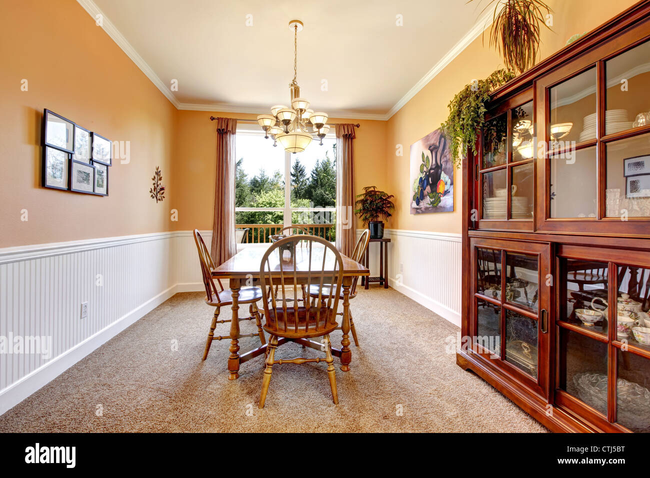 Peach color dining room with beige carpet and simpel furniture. Stock Photo