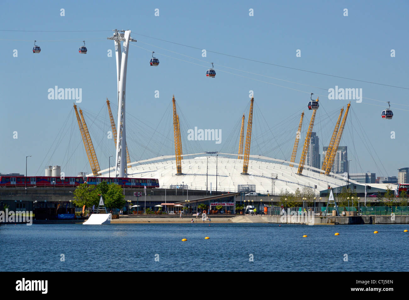 Emirates Air Line cable cars seen in front of The O2 arena dome viewed from Royal Docks crossing River Thames linking to North Greenwich England UK Stock Photo