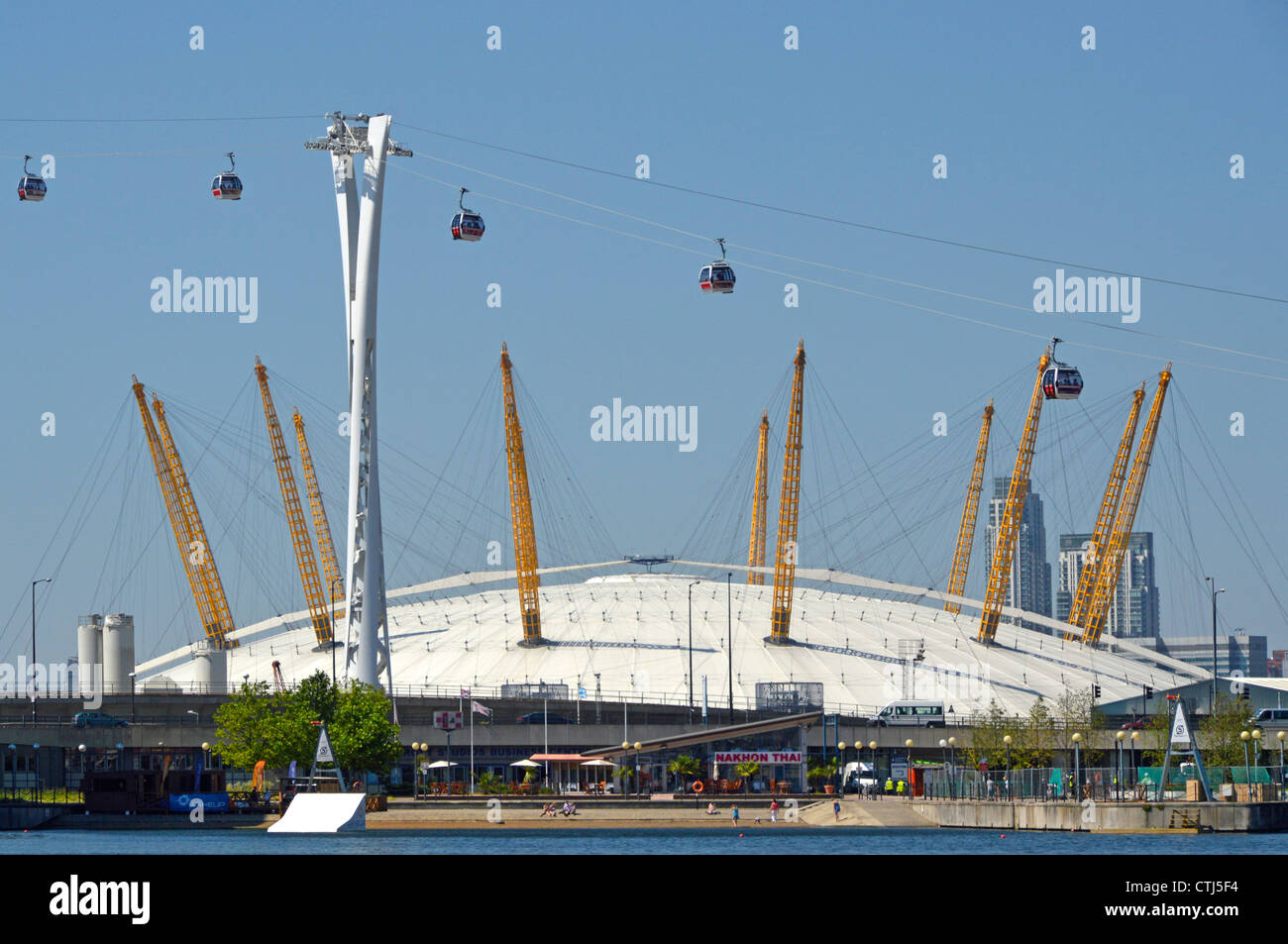Emirates Air Line cable cars seen in front of The O2 arena dome viewed from Royal Docks crossing River Thames linking to North Greenwich England UK Stock Photo