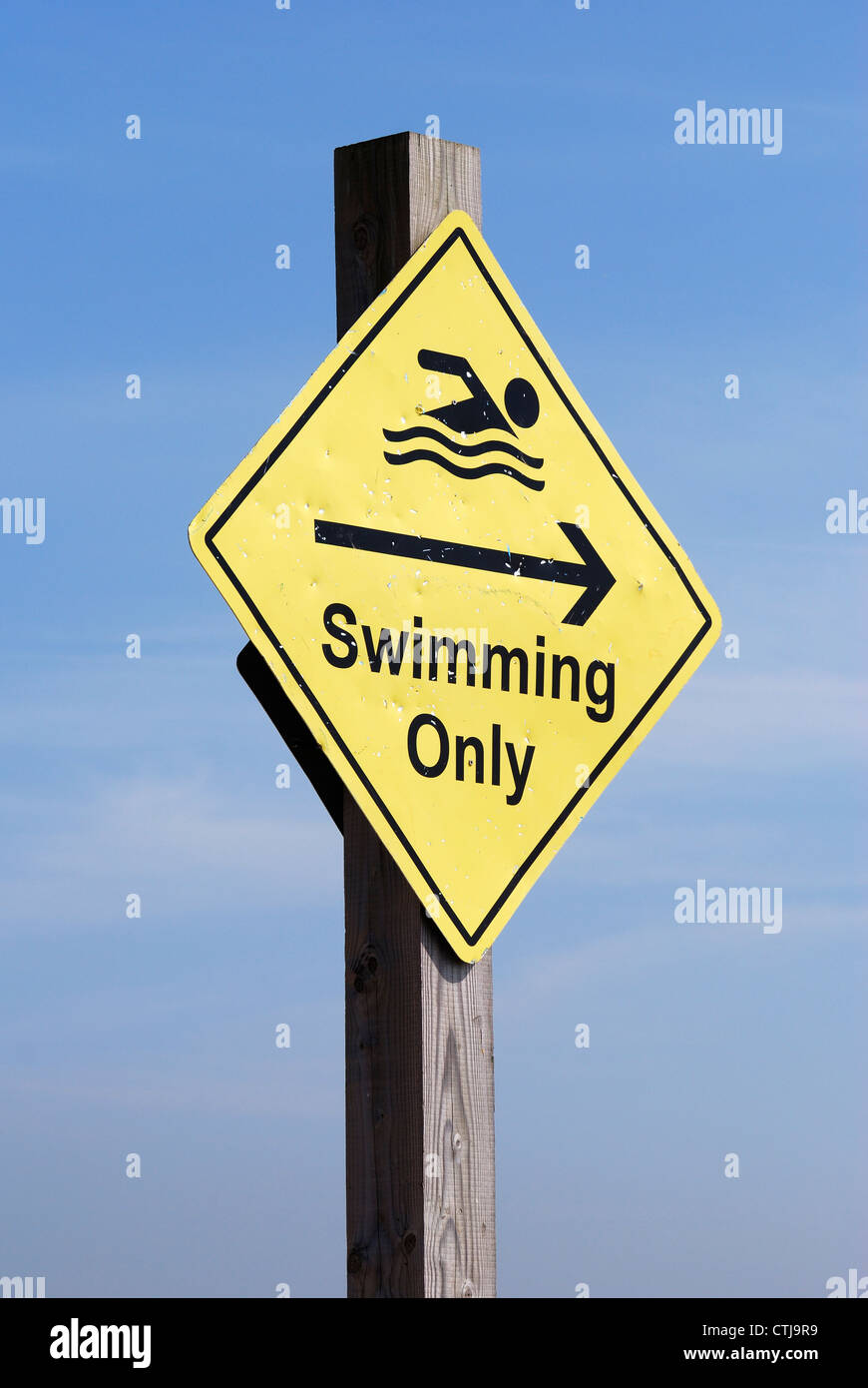 Battered and dented Swimming Only sign on beach at Shoreham. West Sussex. England Stock Photo