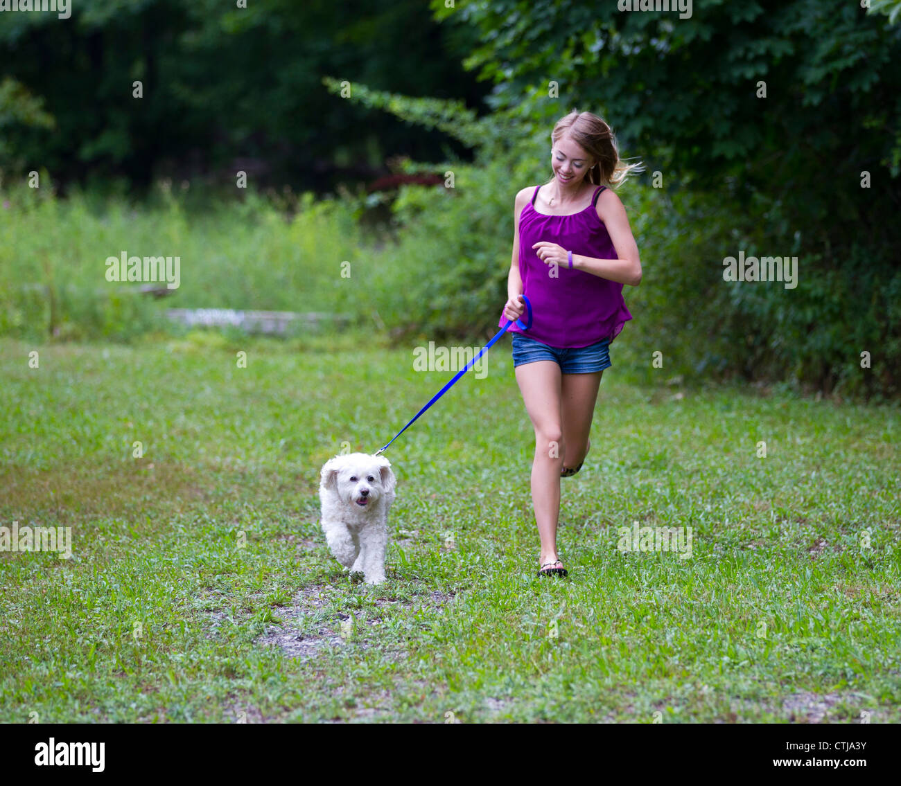 Teenage girl running with her pet dog Stock Photo Alamy