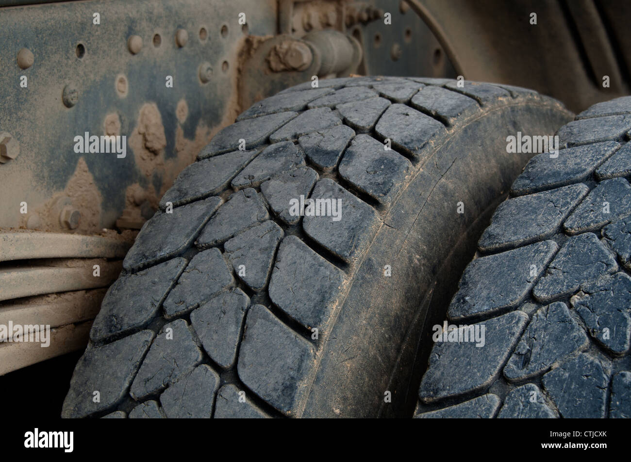 Closeup of large tires and suspension of a dirty dump truck Stock Photo