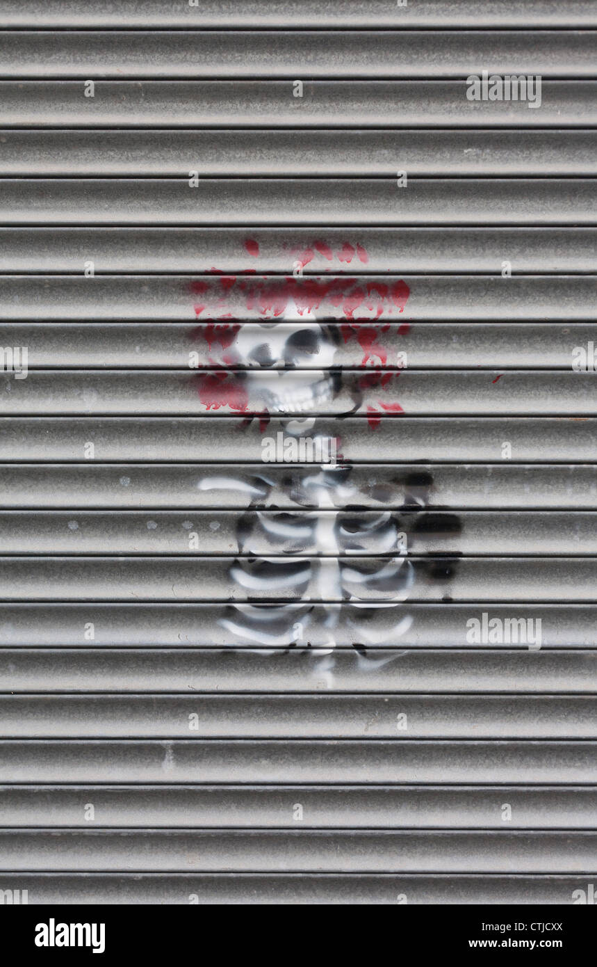 Street art skeleton with red hair graffiti sprayed on metal shutter Stock Photo