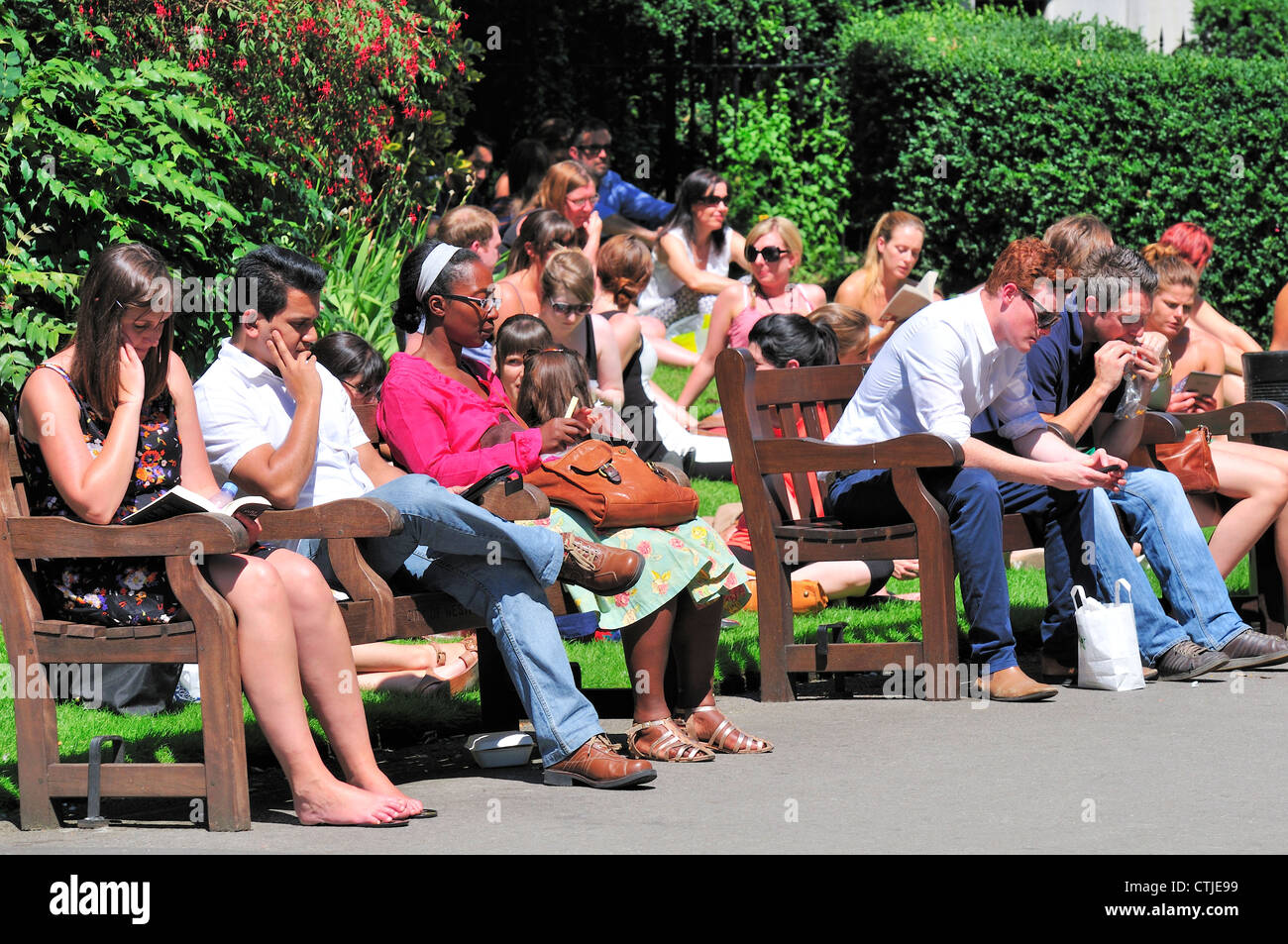 London, England, UK. People enjoying the sun during lunch break in Victoria Embankment Gardens Stock Photo