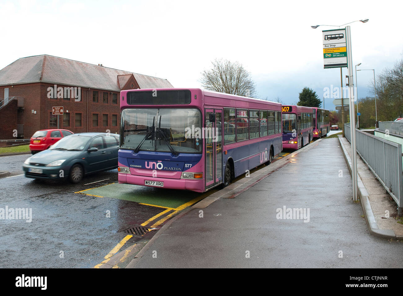 Buses in Uno livery wating behind at a bus stop outside Hatfield Railway Station, England. Stock Photo