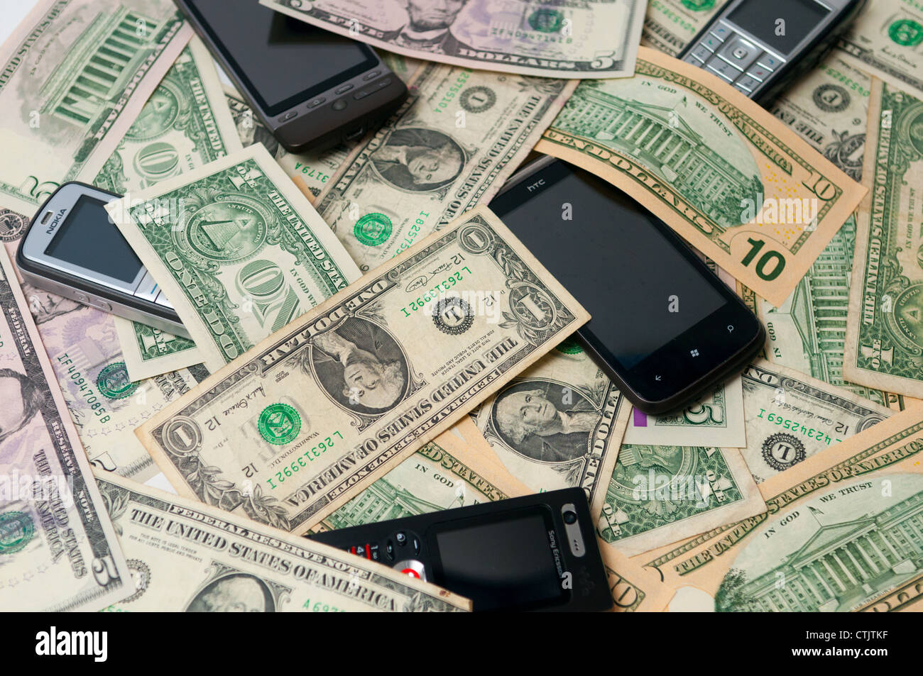 Mobile Phones on a pile of money Stock Photo