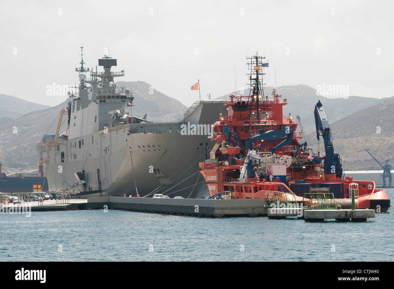 Bow to bow L61 Juan Carlos 1 and the tug Clara Campoamor in Cartagena Harbour Spain Stock Photo