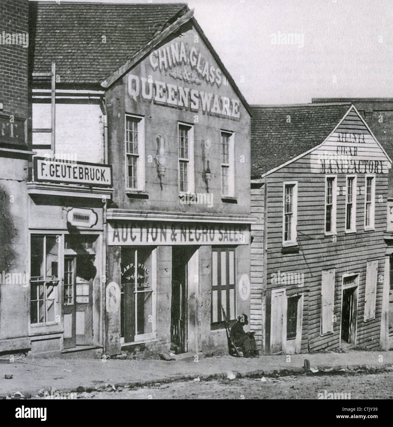 SLAVE AUCTION HOUSE in Atlanta, Georgia about 1864 between a tobacco shop and a cigar factory on Whitehall Street (today called Peachtree Street) Note the guard's rifle. Photo by George Barnard (1819-1902) most famous for his Civil War photos. Stock Photo