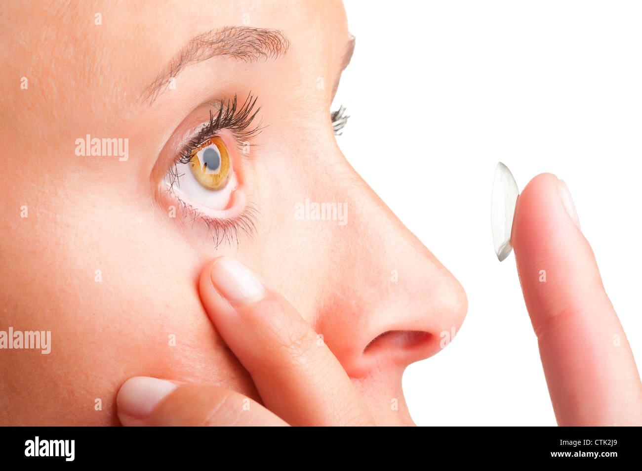 Closeup of a woman inserting a contact lens in her eye Stock Photo