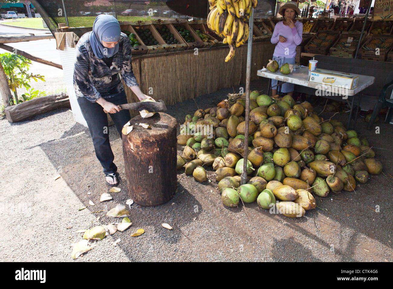 Woman cutting coconuts to sell coconut water in Hawaii Stock Photo Alamy