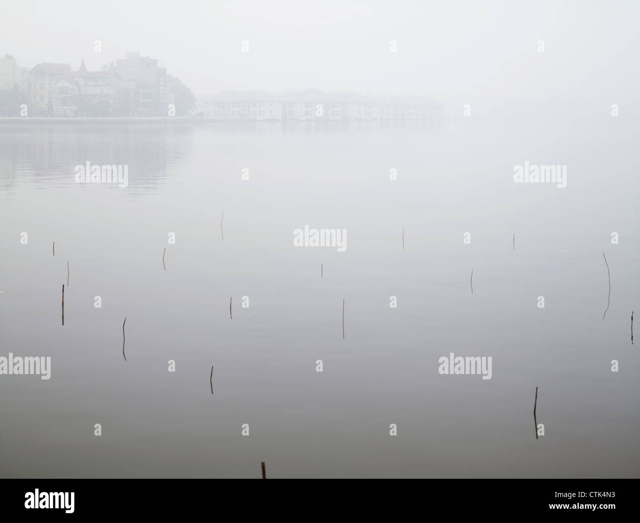 Poles, debris and benches sticking up out of the West Lake, a large freshwater lake in Hanoi, Vietnam Stock Photo