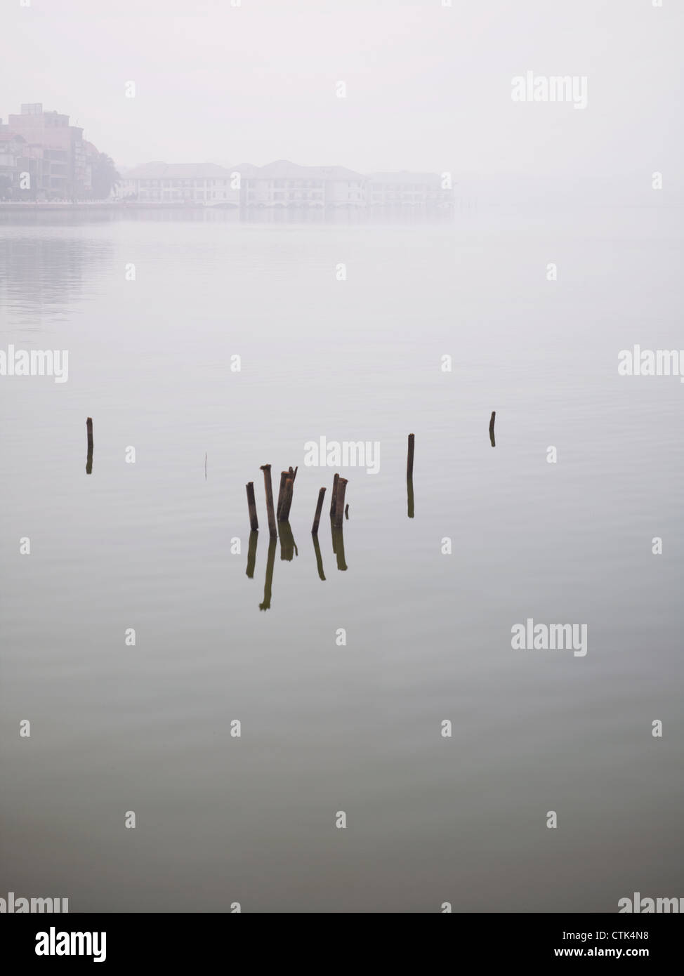 Poles, debris and benches sticking up out of the West Lake, a large freshwater lake in Hanoi, Vietnam Stock Photo