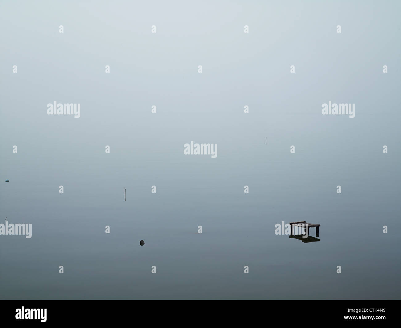 Poles, debris and benches sticking up out of the West Lake, a large freshwater lake in Hanoi, Vietnam Stock Photo