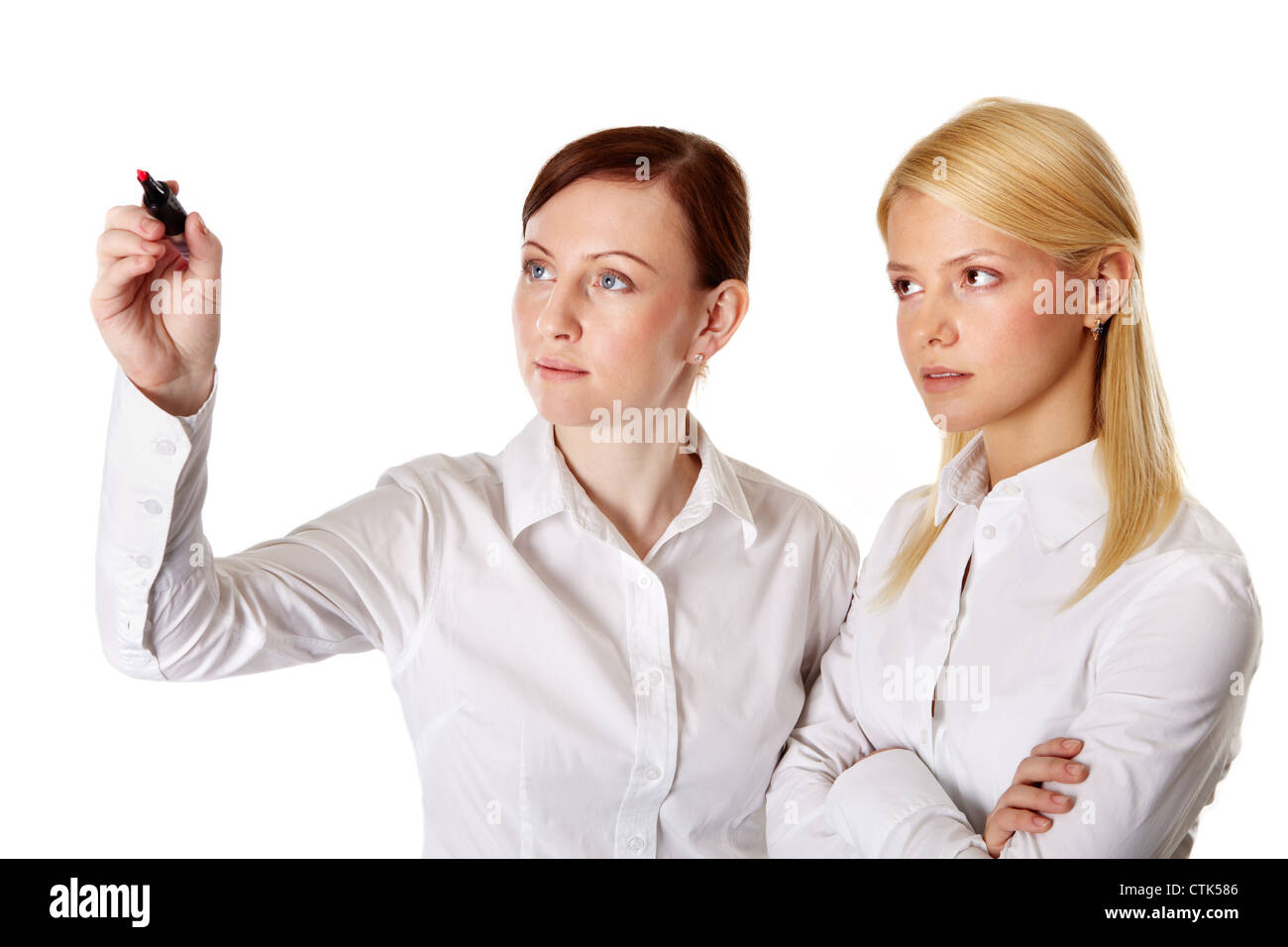 Business team of two pretty ladies writing on the screen with red marker, isolated on white Stock Photo