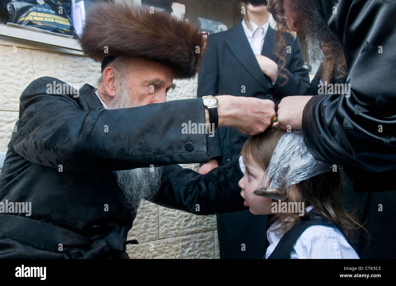 Rabbi cuts child's hair in a Halake ceremony in Bar Yochai tomb in Meron , Israel Stock Photo