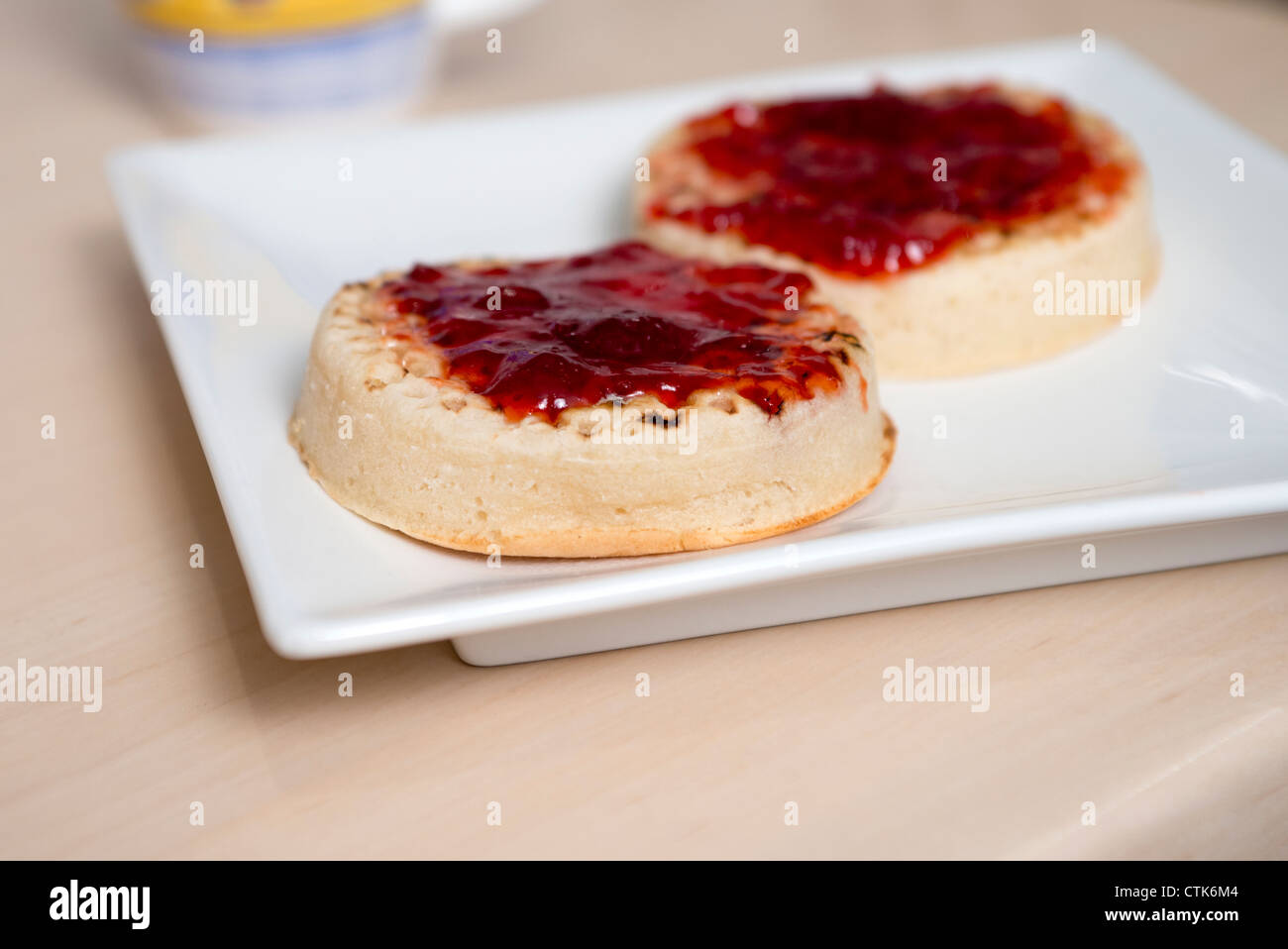 afternoon tea with two crumpets with strawberry jam Stock Photo Alamy