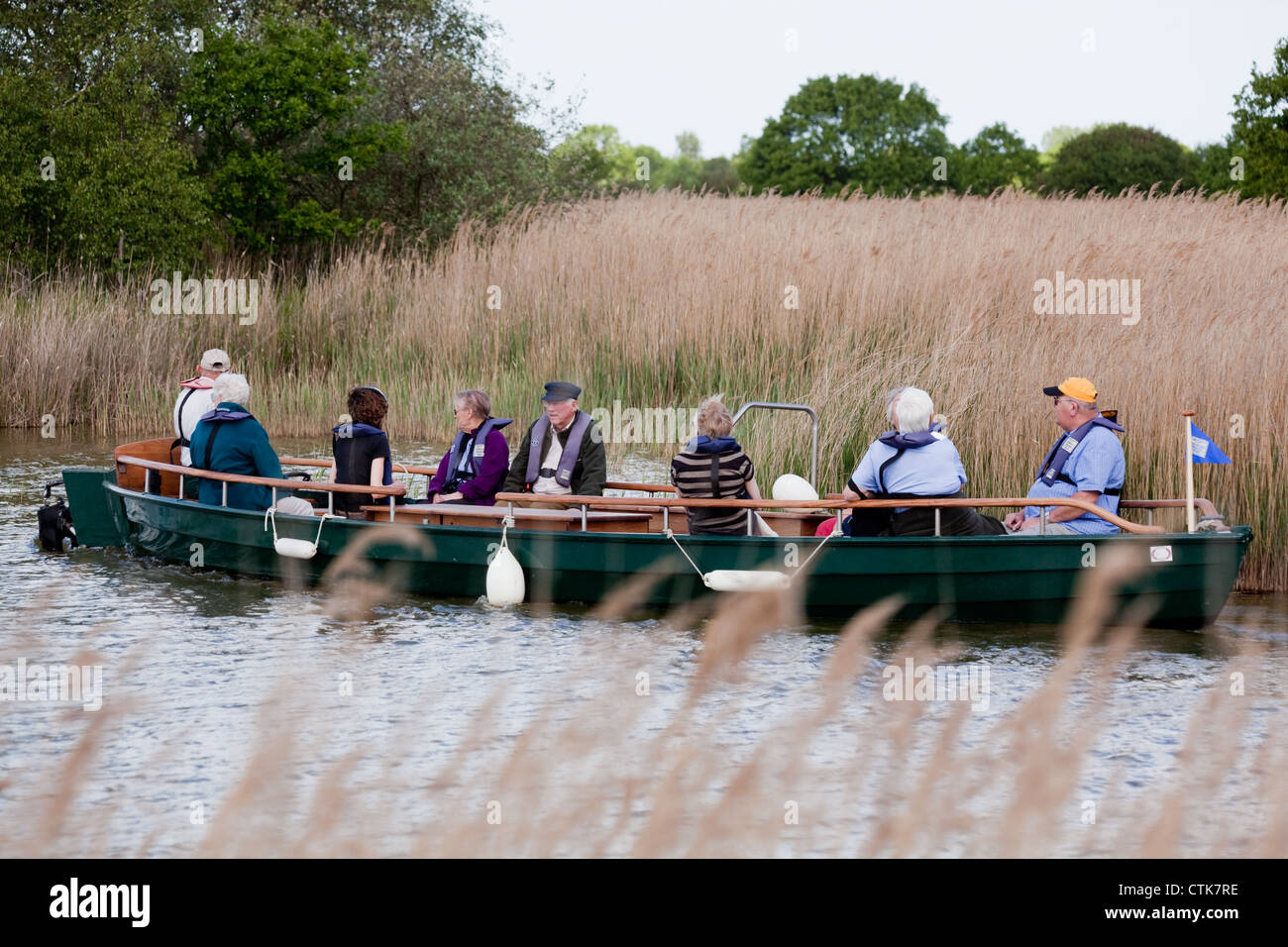 Norfolk Wildlife Trust. Water Trail Guide and electric boat, with visitors on board. Hickling Broad Nature Reserve. Norfolk. NWT Stock Photo