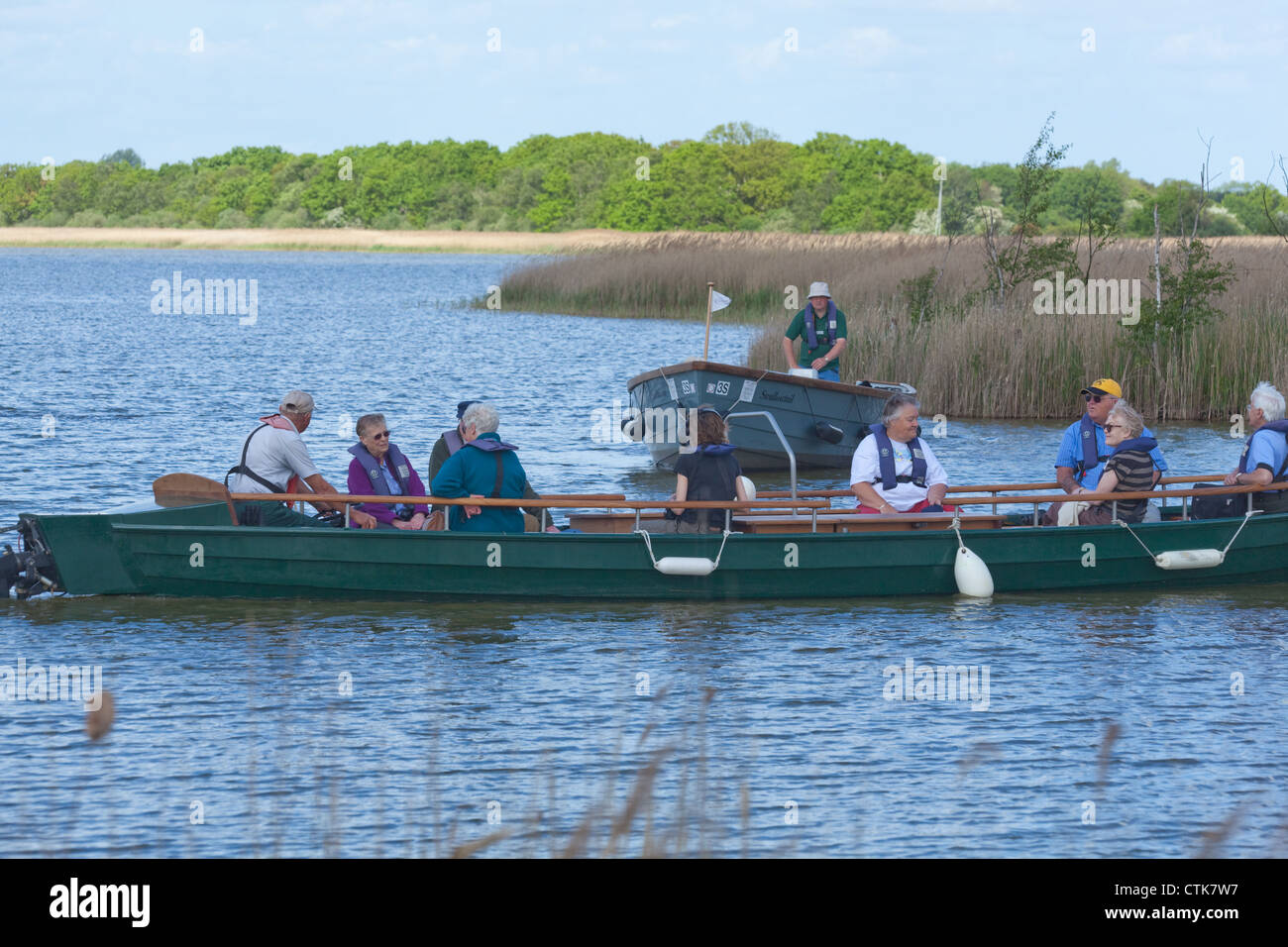 Norfolk Wildlife Trust. Water Trail Guide and electric boats, with visitors on board. Hickling Broad Nature Reserve. Norfolk. Stock Photo