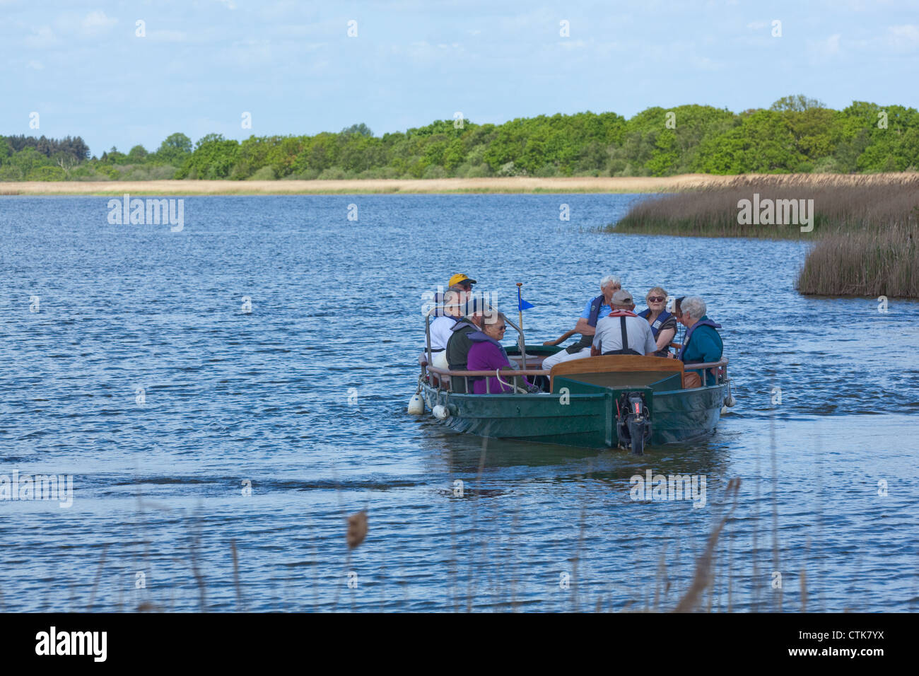 Norfolk Wildlife Trust Water Trail Guide and electric boat, 'Swallowtail', with visitors on board. Hickling Broad Nature Reserve Stock Photo