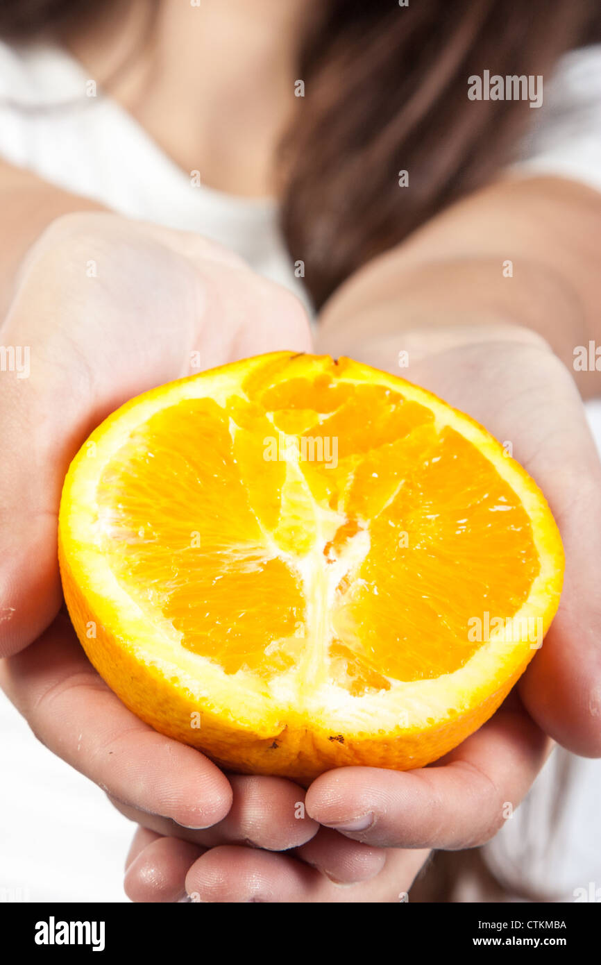 Young woman holding a orange Stock Photo - Alamy