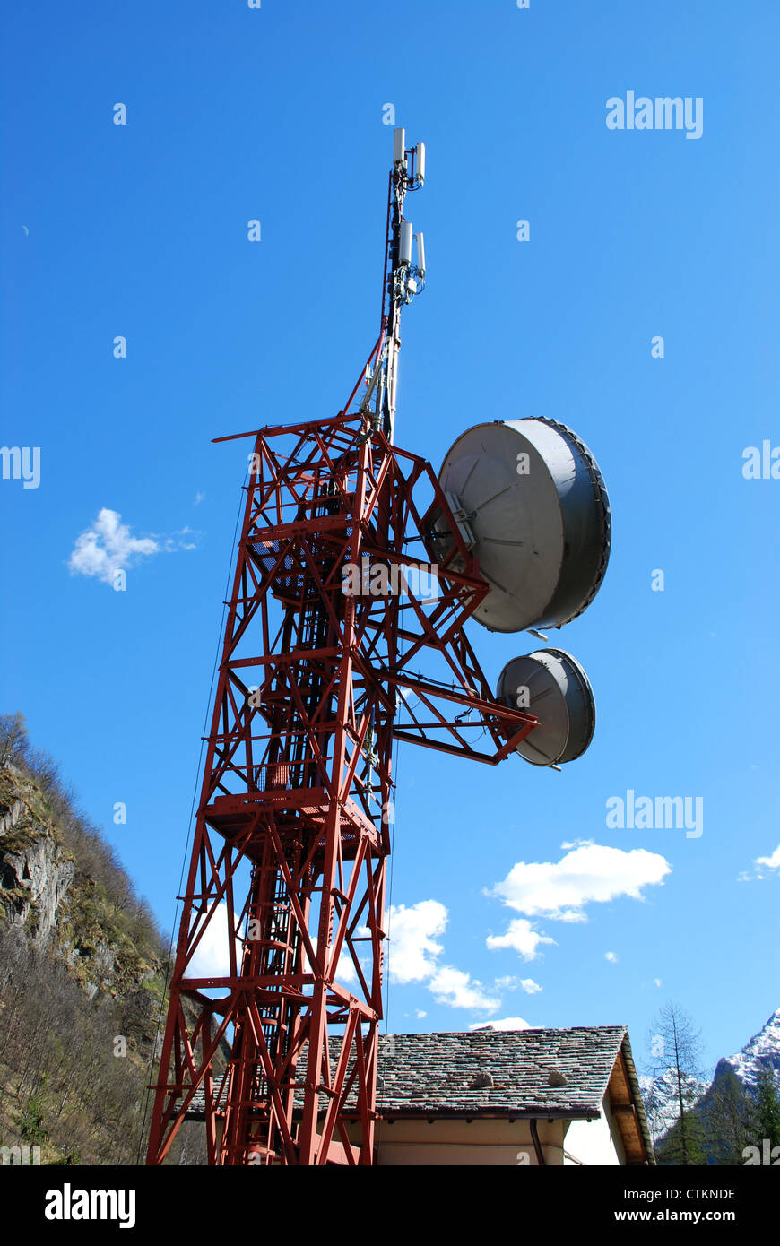 Huge communication antenna tower and satellite dishes against blue sky Stock Photo