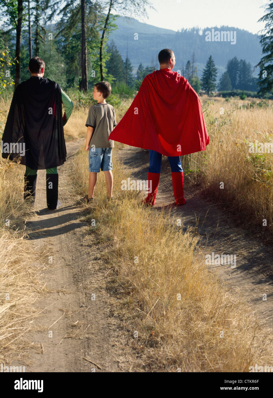A young boy standing with superheroes Stock Photo