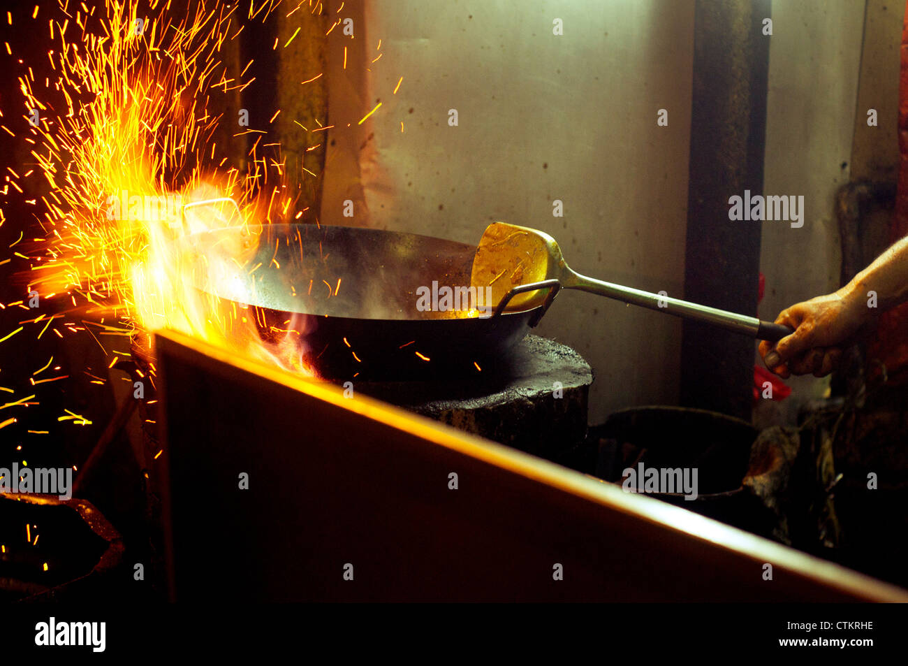 wok cooking with fire sparks Stock Photo Alamy