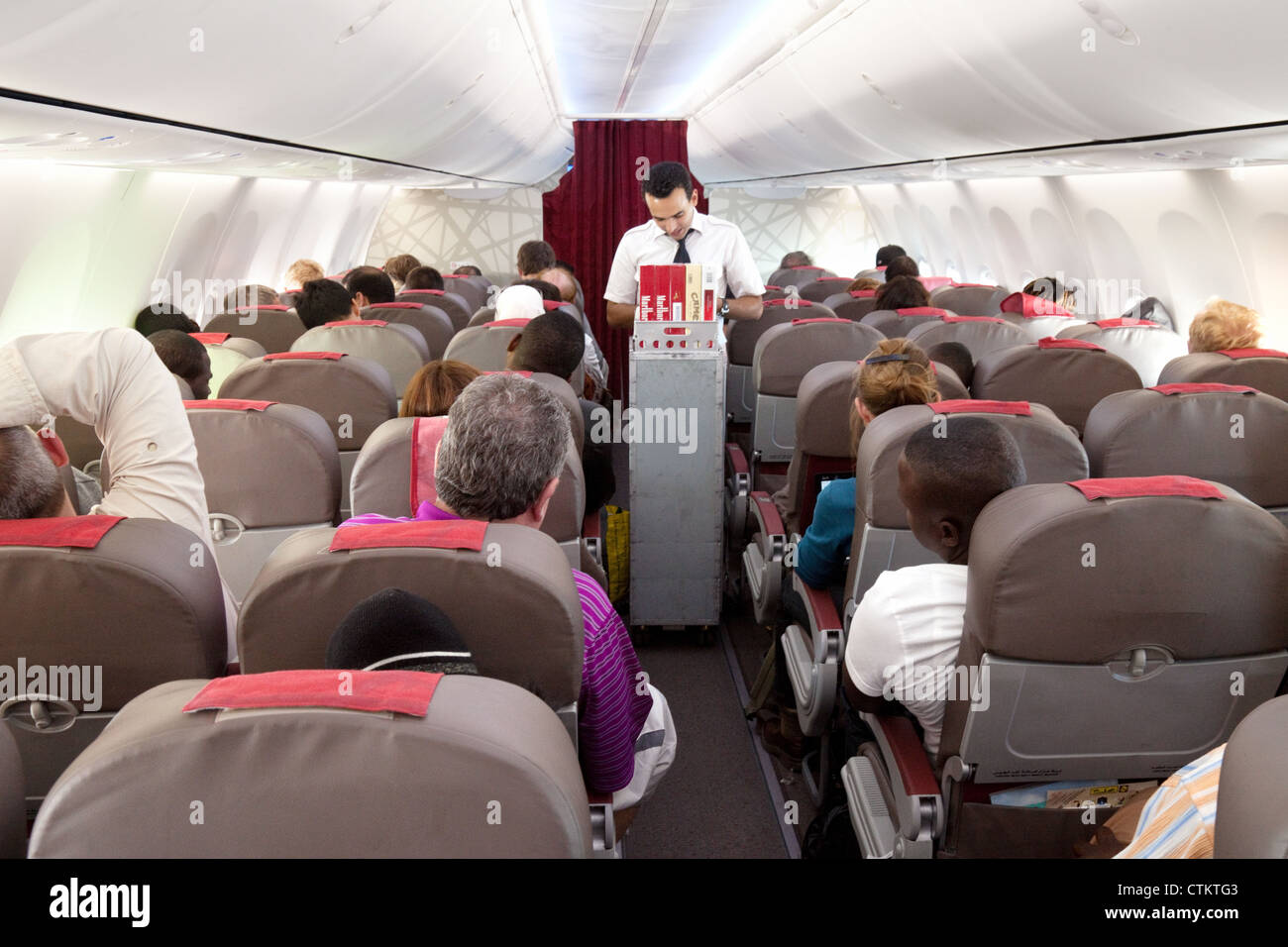 Air crew selling duty free goods in flight interior of a plane, Royal Air Maroc Stock Photo