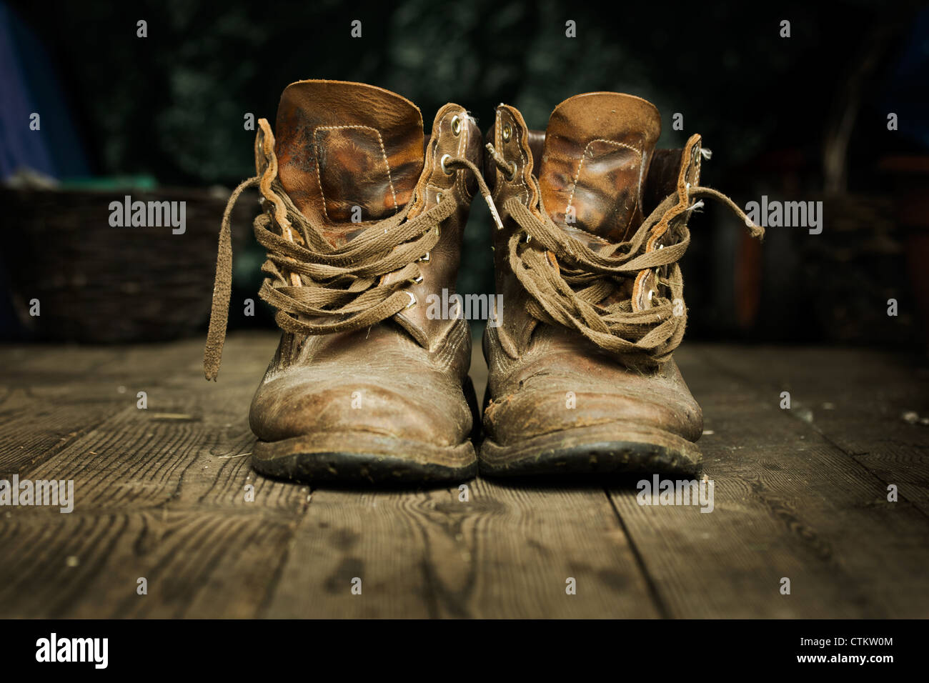 Pair of old worn boots on wooden floor boards Stock Photo
